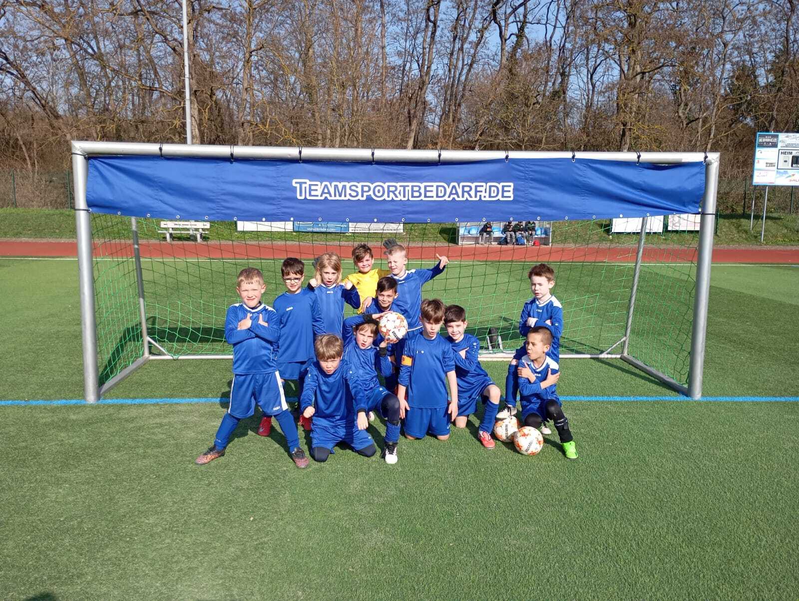 Gruppenfoto einer Fu&szlig;ballmannschaft vor dem Tor
