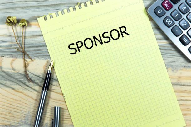 Gelbes kariertes Notizblatt mit der Aufschrift "SPONSOR", daneben ein Taschenrechner und zwei schwarze Stifte.